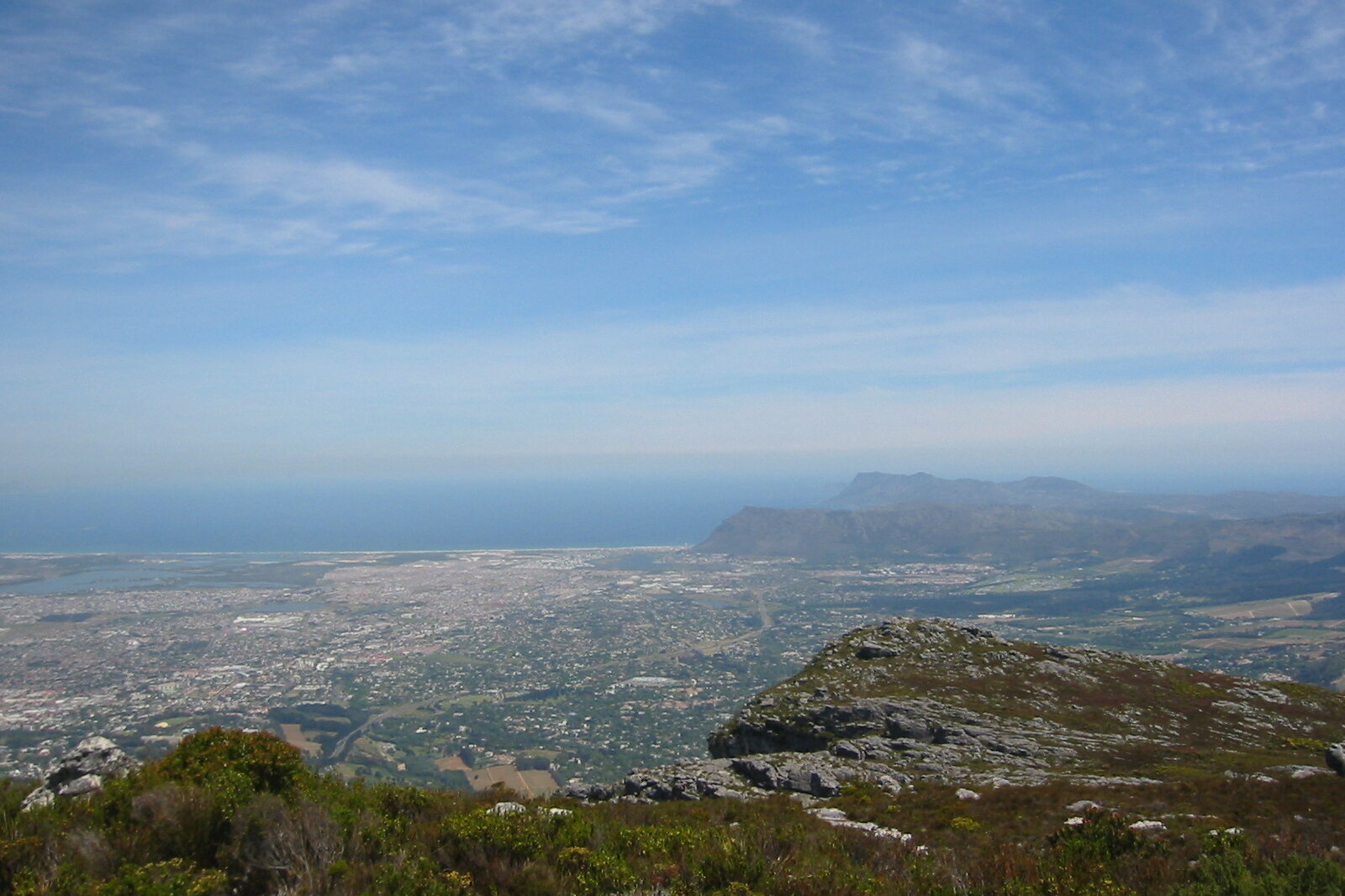 View from the summit of Table Mountain over Cape Town city bowl and the Atlantic at golden hour