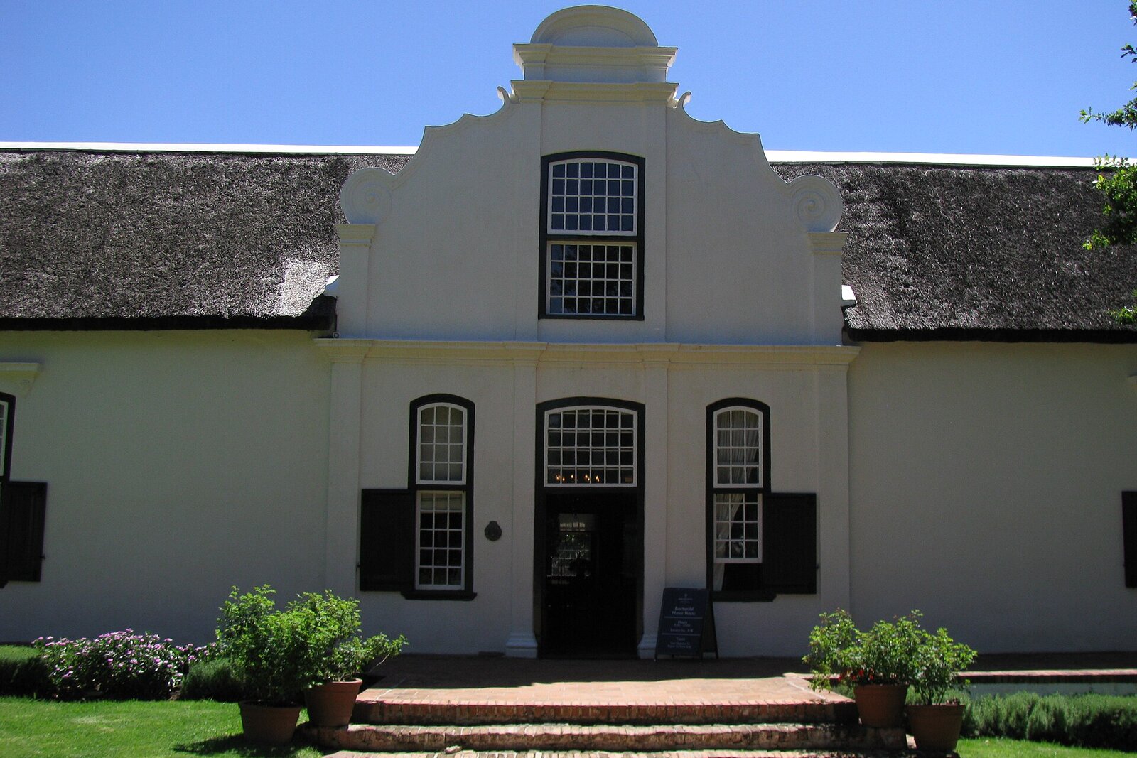 Whitewashed gabled Cape Dutch wine estate building in the Cape Winelands