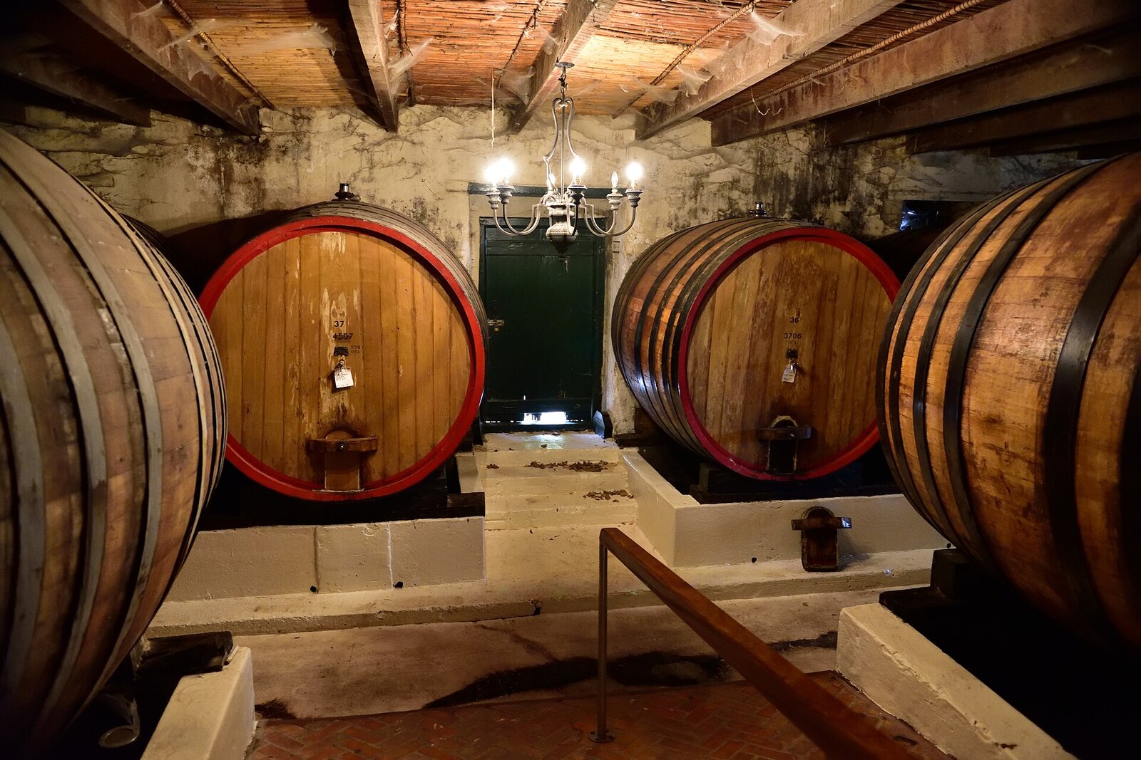 Oak barrels stacked in a traditional wine cellar at a Stellenbosch estate